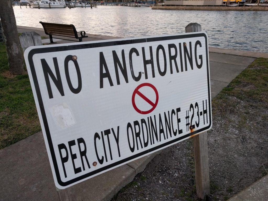 A sign says "No Anchoring Per City Ordinance" in Florida