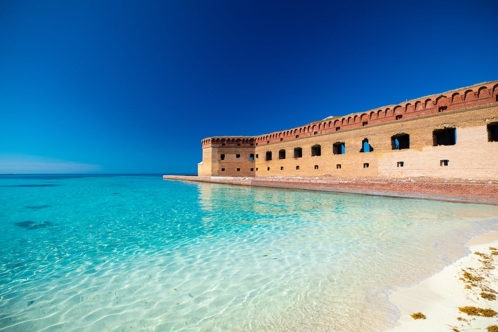 White sand beach and crystal clear water in Dry Tortugas National Park, Florida. Fort Jefferson is in the background. DP